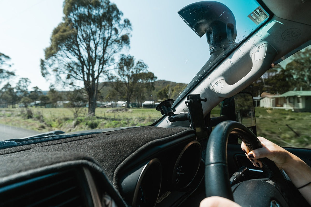 RAM suction phone mount installed near the lower edge of a vehicle windscreen
